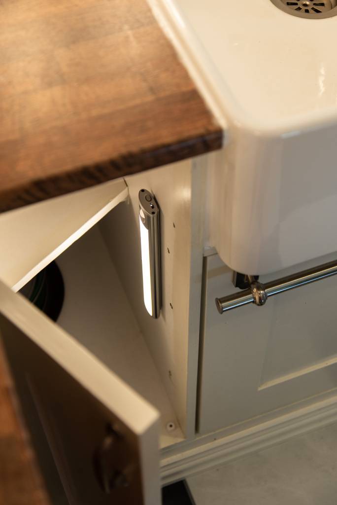 Lampe Wanda rechargeable montée verticalement pour éclairer les deux étagères d'un meuble de cuisine